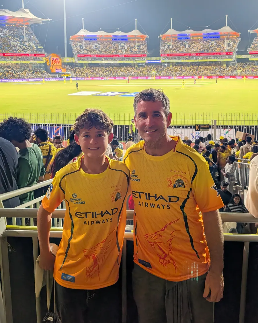 Leon and his son in yellow jerseys at a packed night match in Chennai